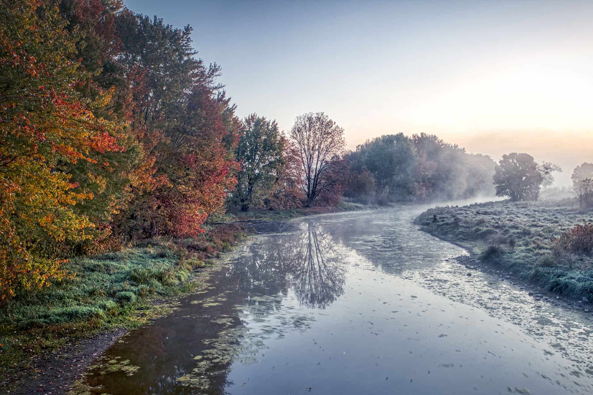 An image of a calm river during the fall.